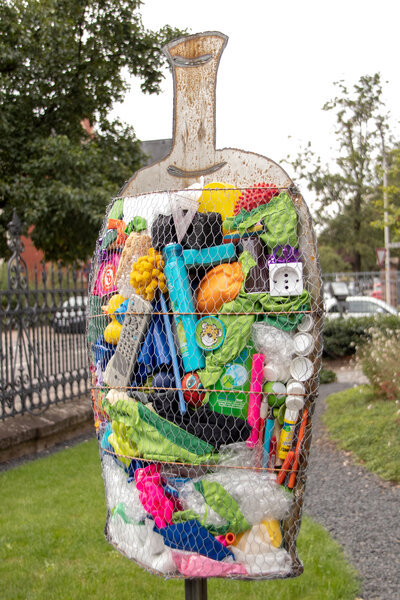 Eine Fischskulptus ist mit Plastikmüll gefüllt.